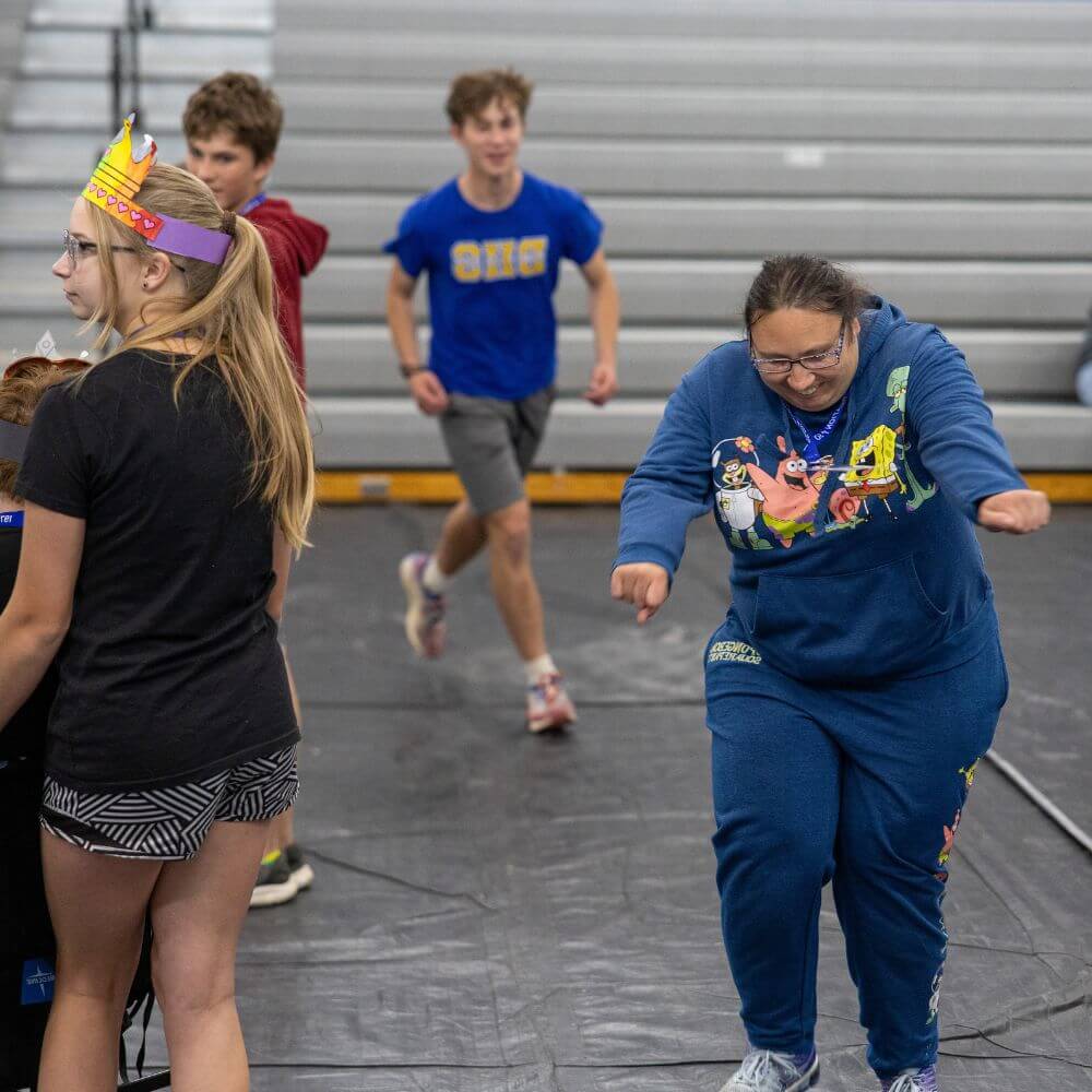 Camper and volunteers playing around in gym at Camp ReCreation